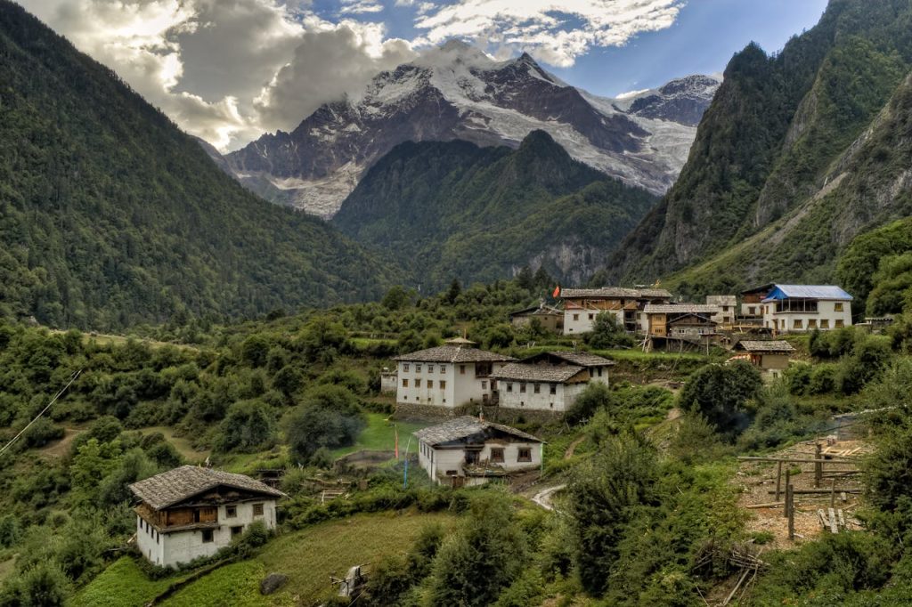 Picturesque village nestled in the Himalayas with lush greenery and towering mountains.